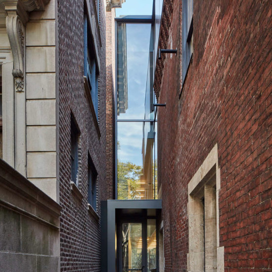 a narrow brick alley with a black door