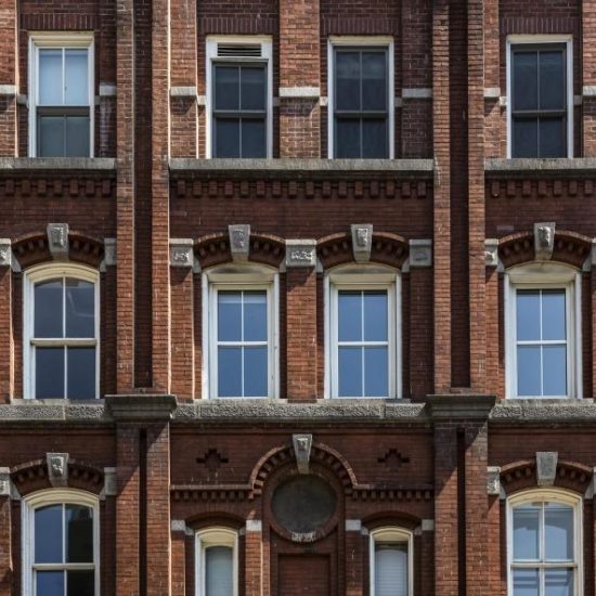 a large brick building with many windows and arched doorways