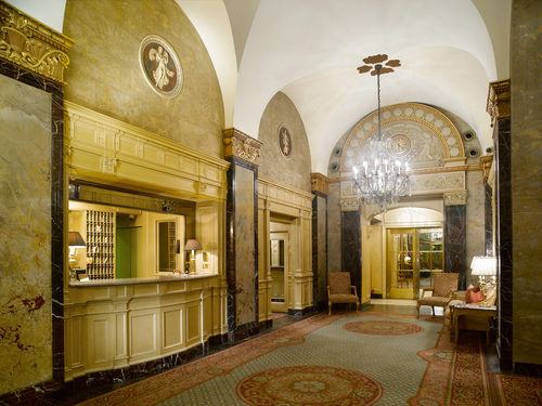 a large hallway with chandelier and marble walls