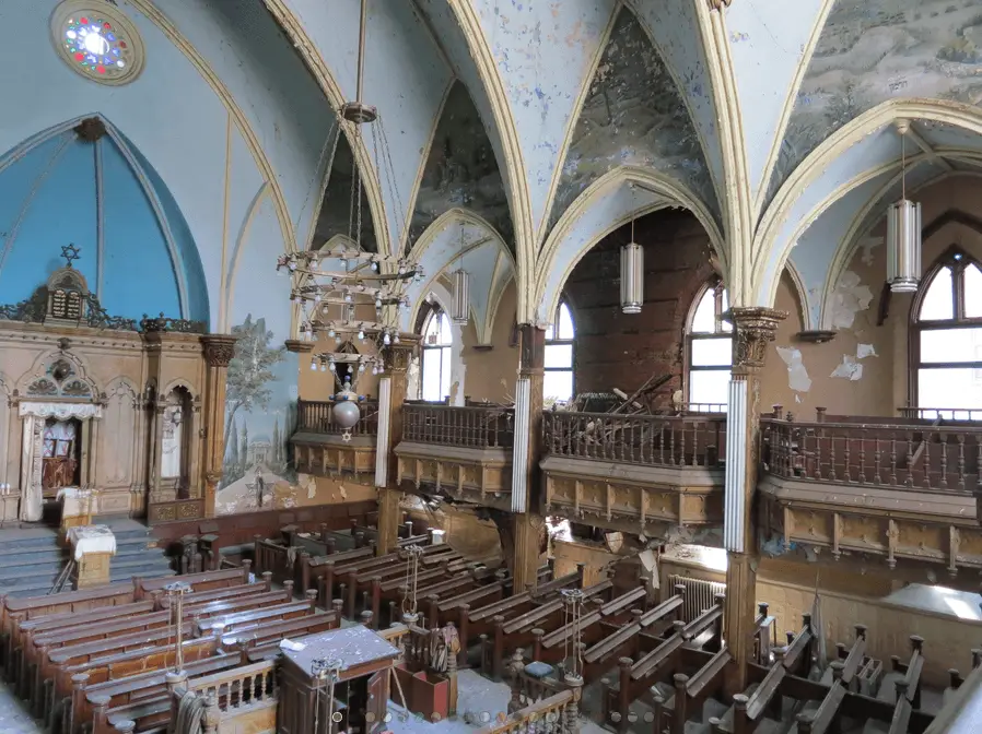 the inside of a church with pews and stained glass windows