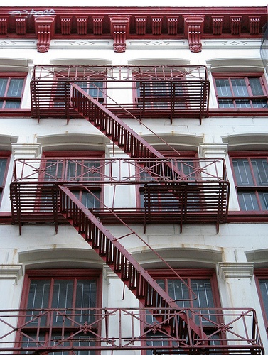 a red fire escape staircase on the side of a building