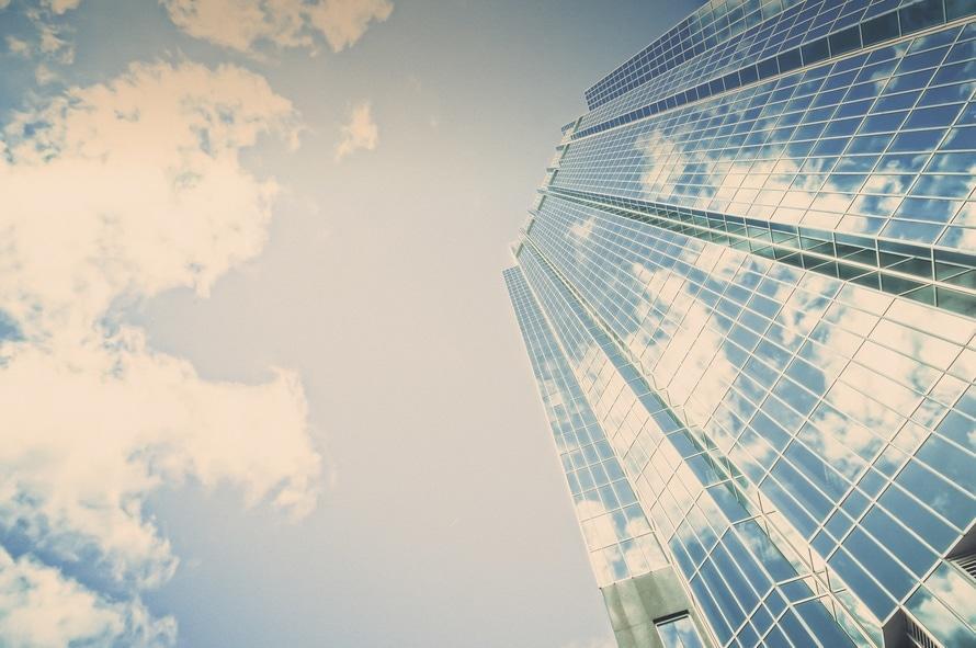 a tall building with many windows and clouds in the sky