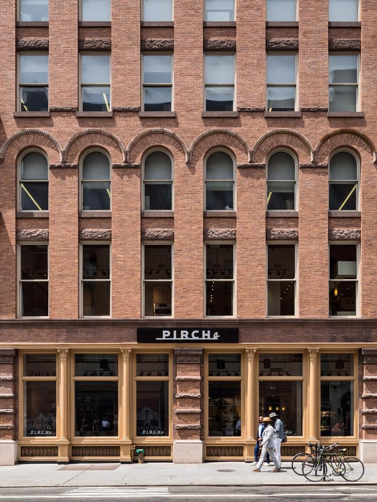 a man walking past a tall brick building