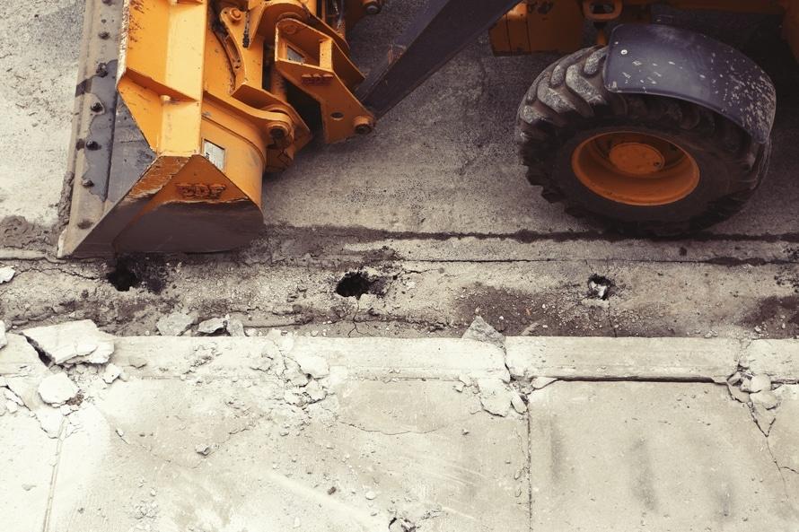 a large yellow bulldozer sitting on top of a cement slab