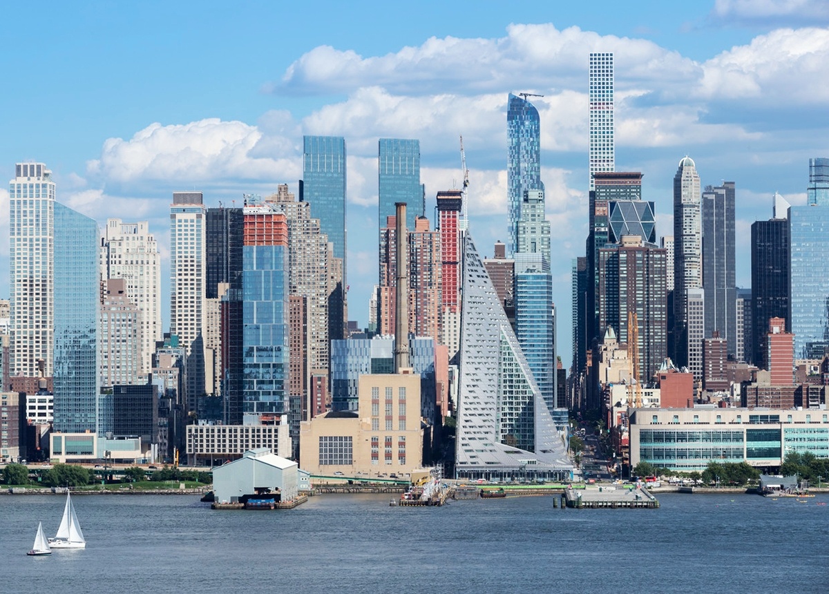 a city skyline with tall buildings and a sailboat in the water