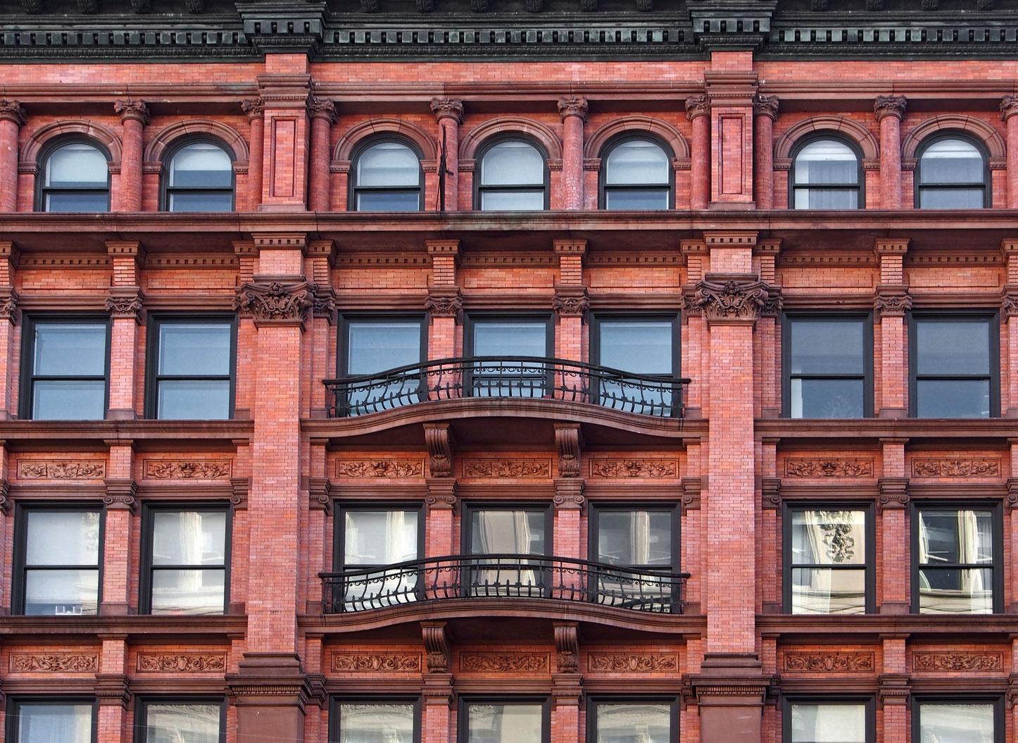a red brick building with many windows and balconies