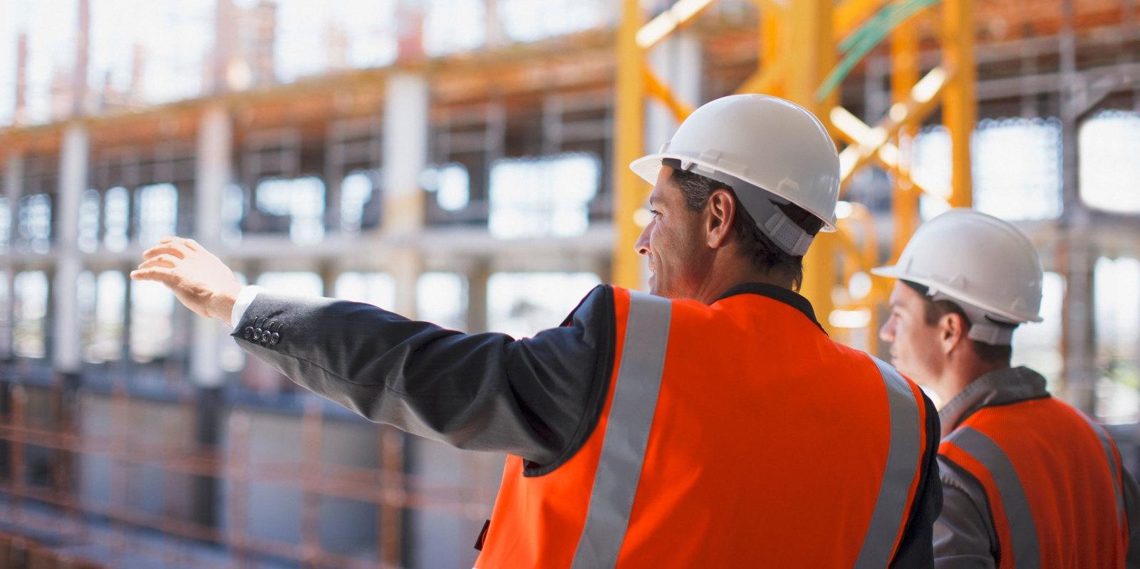 two men in orange vests and hard hats