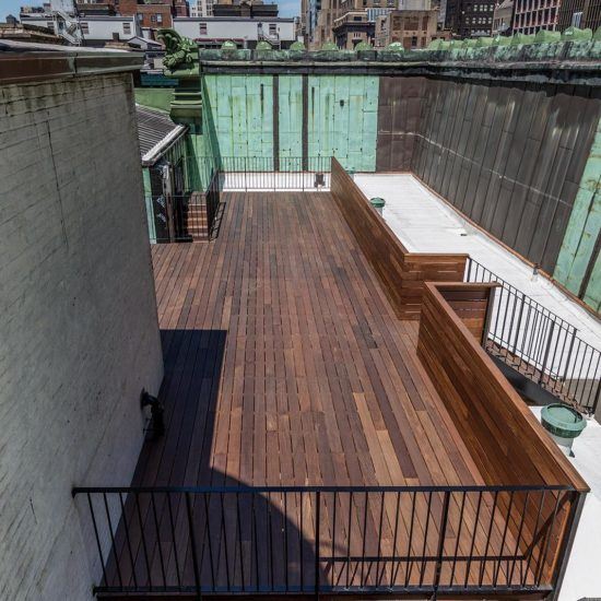 an elevated deck with benches and grills in the city