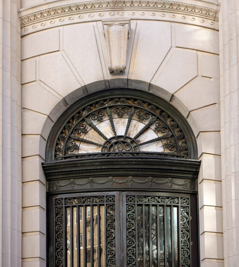 an ornate iron door on the side of a building