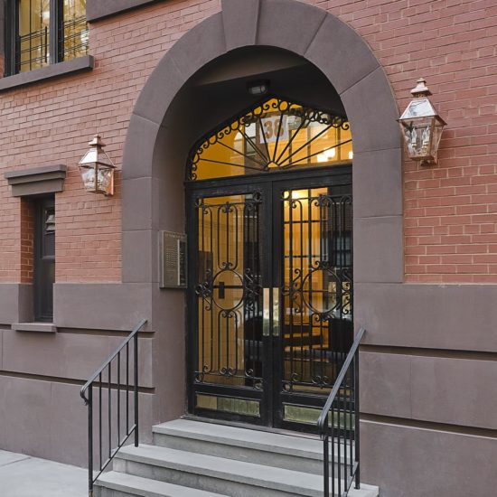 the entrance to a brick building with wrought iron doors