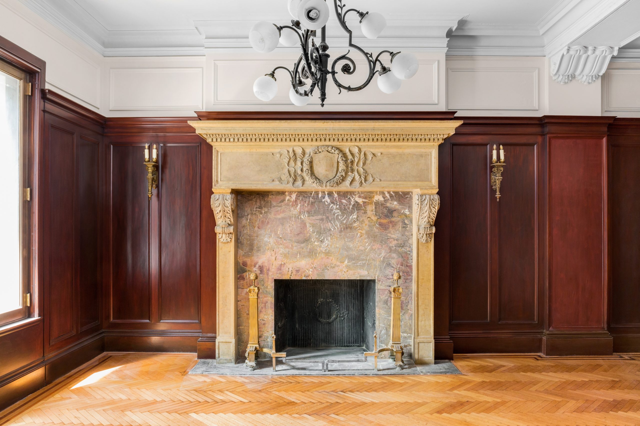 an empty room with a fireplace and chandelier