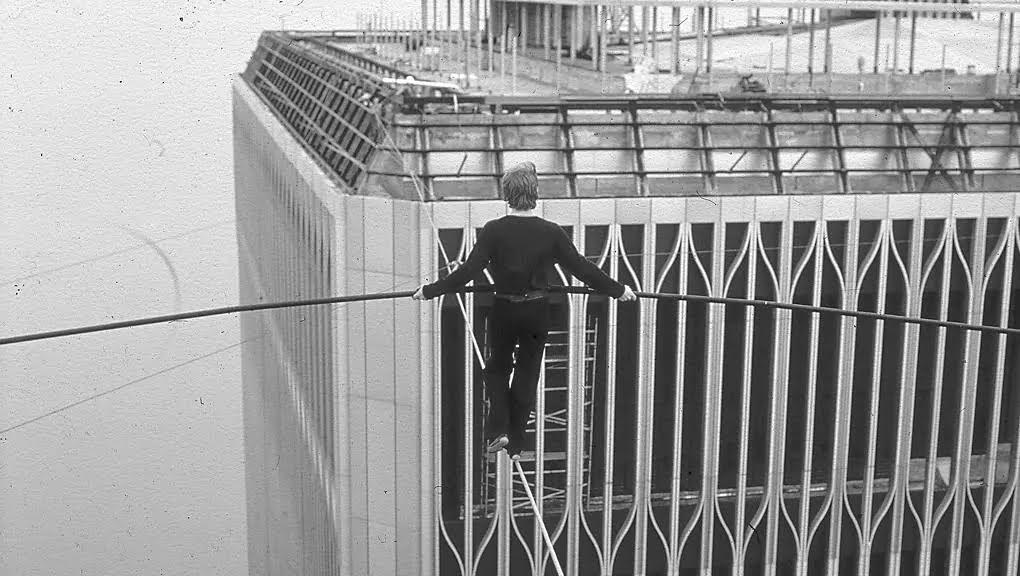 a man standing on a metal railing in front of a building