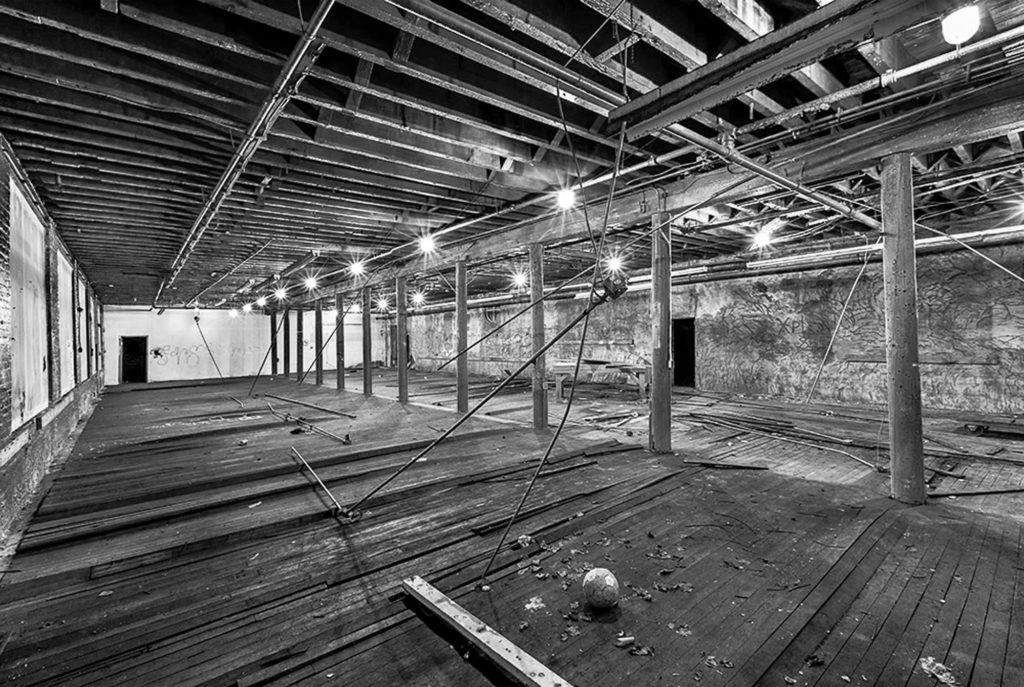 an empty room with wooden floors and exposed ceilings