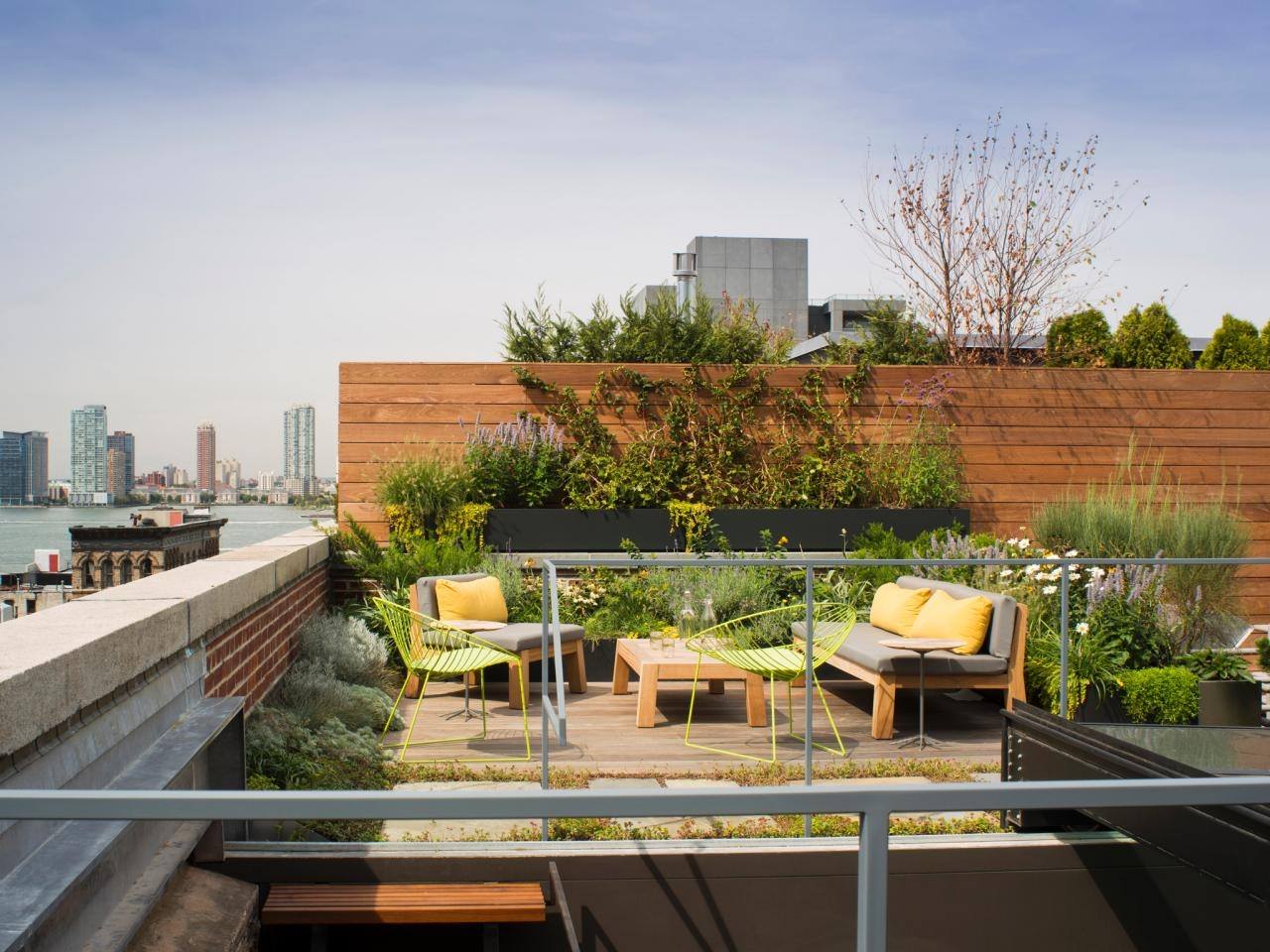 a rooftop garden with seating and plants on it