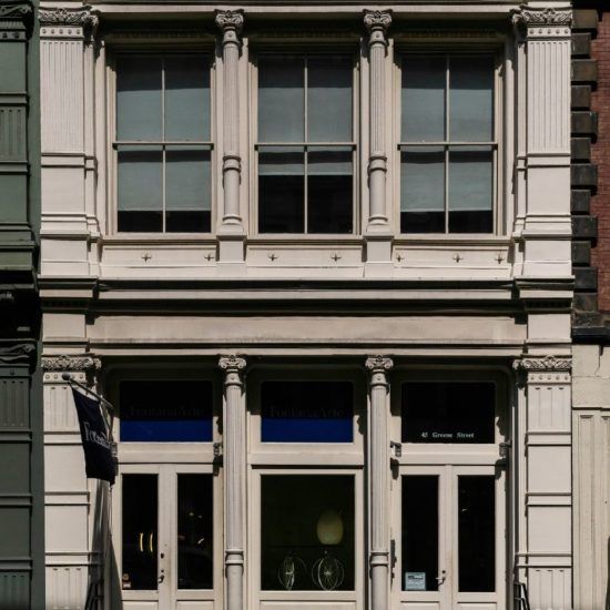 the front of a building with a clock on it's side