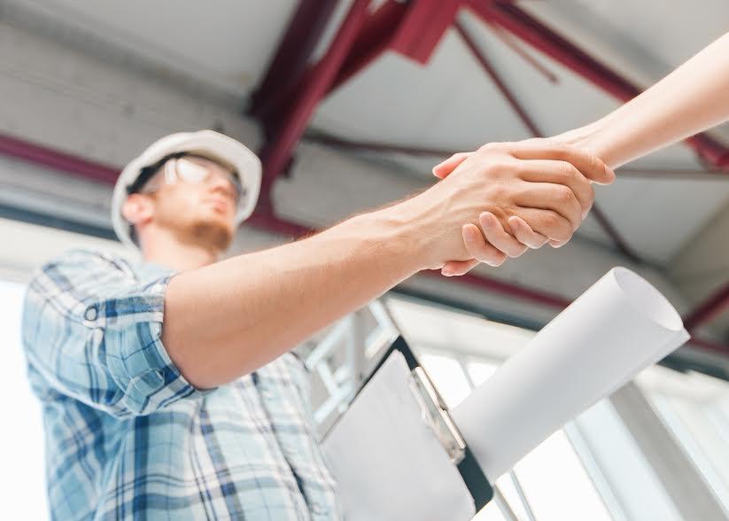 two people shaking hands over a piece of paper