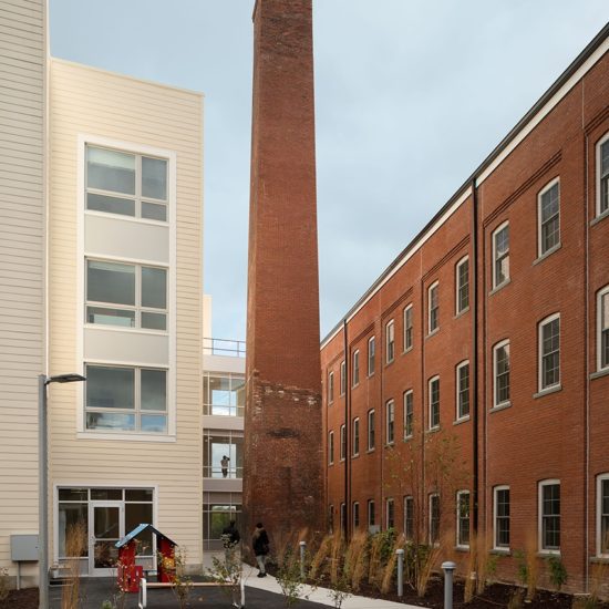a brick building with two tall towers next to it