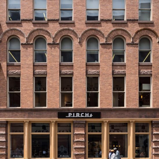 a man walking past a tall brick building