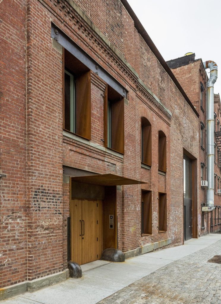 an old brick building with wooden doors and windows