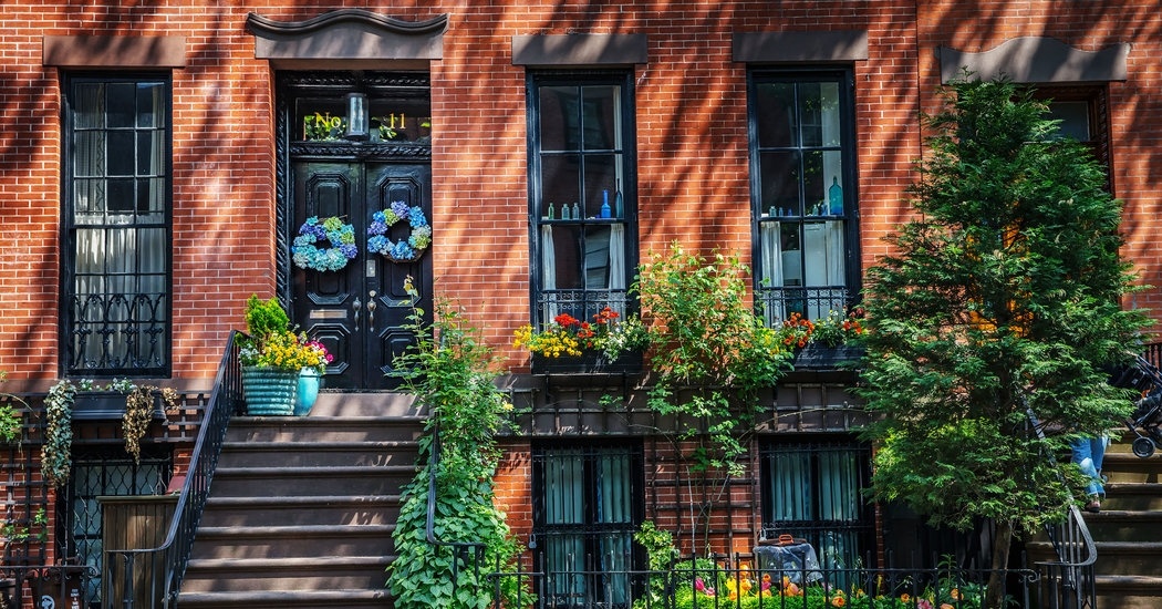 a brick building with flowers and plants on the steps