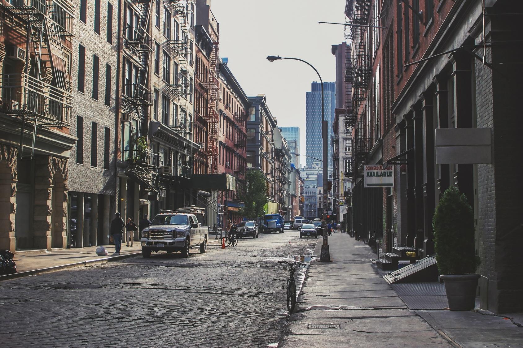 a city street lined with tall buildings and parked cars