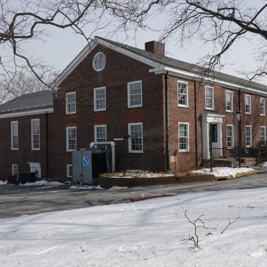 an old brick building with snow on the ground