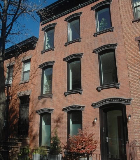 an apartment building with many windows and a car parked on the street