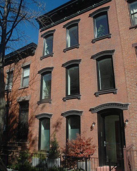 an apartment building with many windows and a car parked on the street