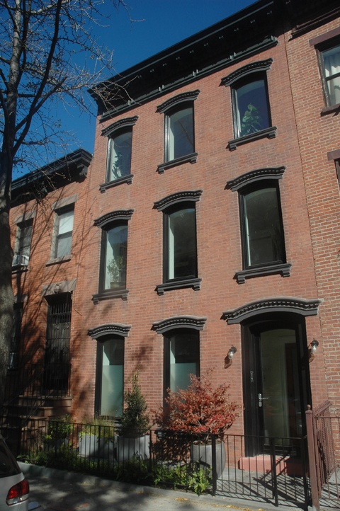 an apartment building with many windows and a car parked on the street