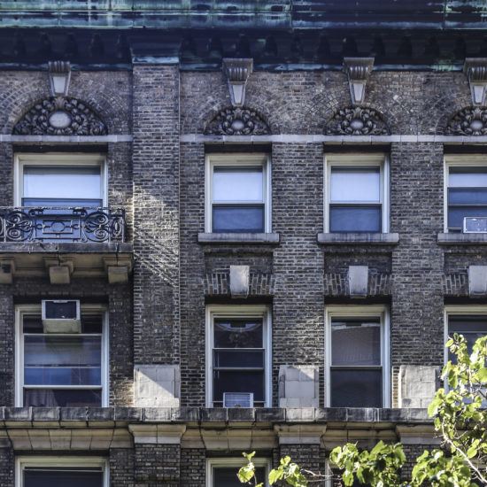 a tall brick building with many windows and balconies