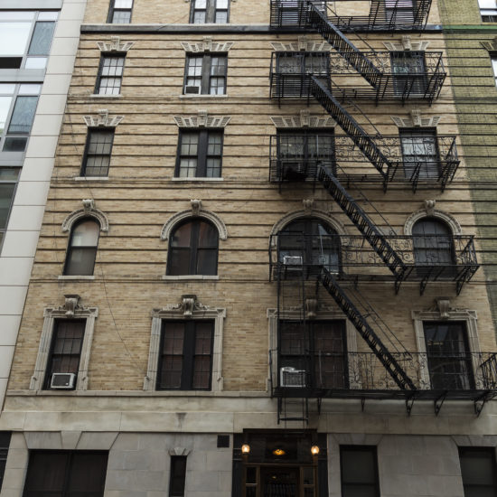 a tall building with lots of windows and a fire escape