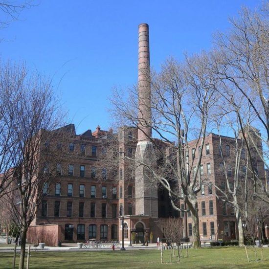 an old brick building with trees in front of it