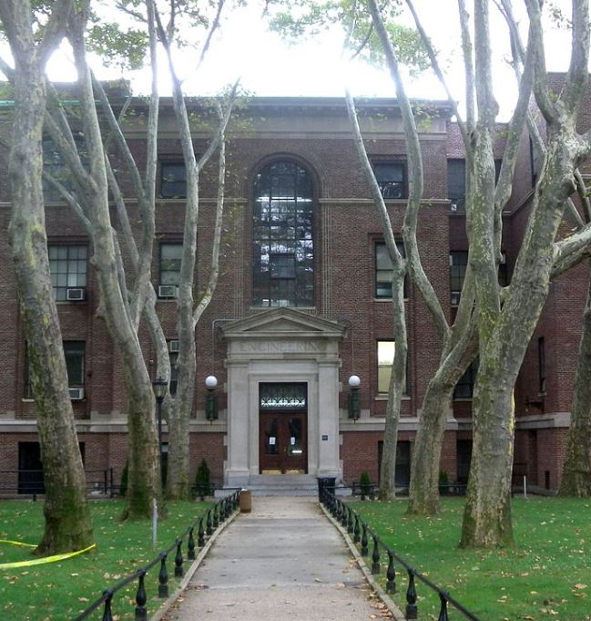 a brick building with many trees in front of it