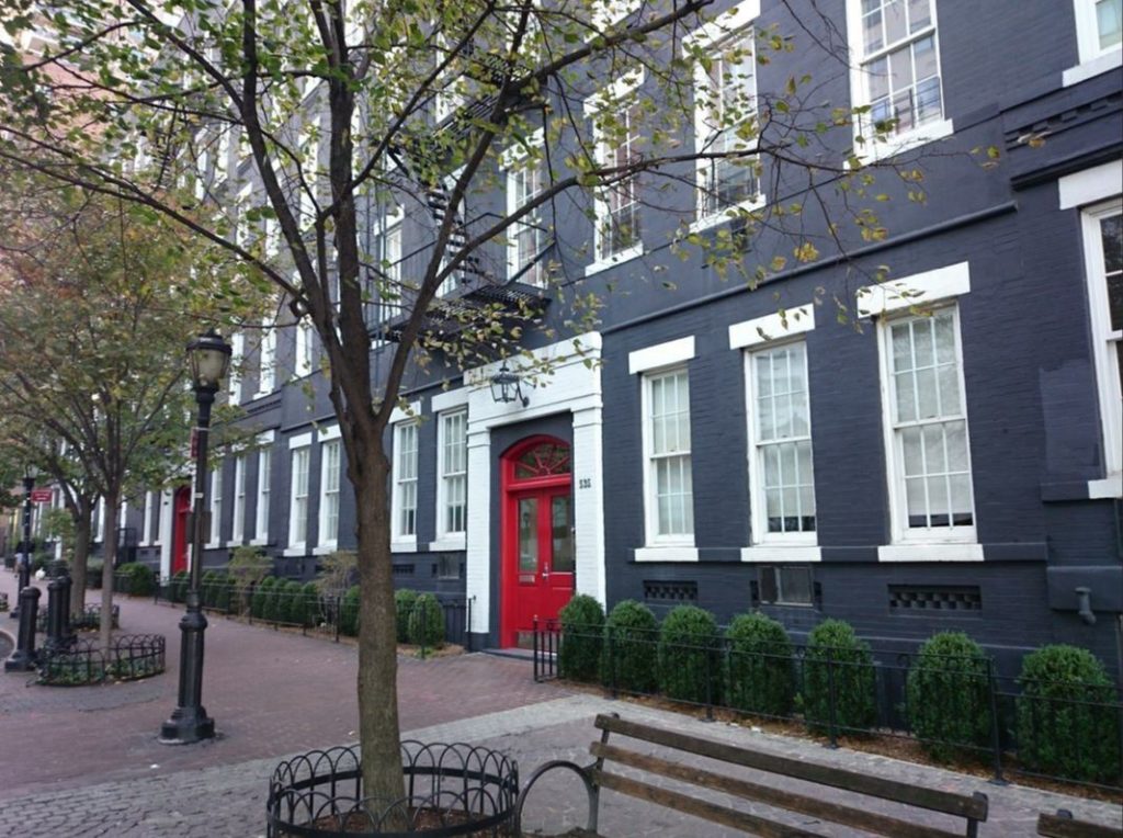 a red door is on the side of a black building