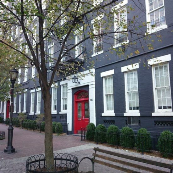 a red door is on the side of a black building