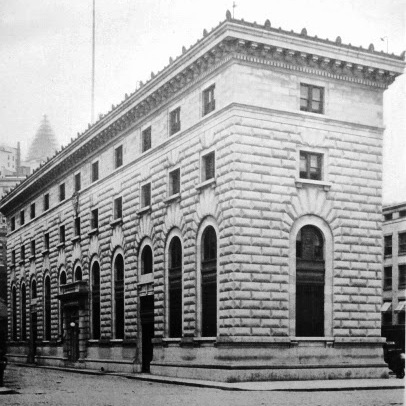 an old photo of a building on the corner of a street