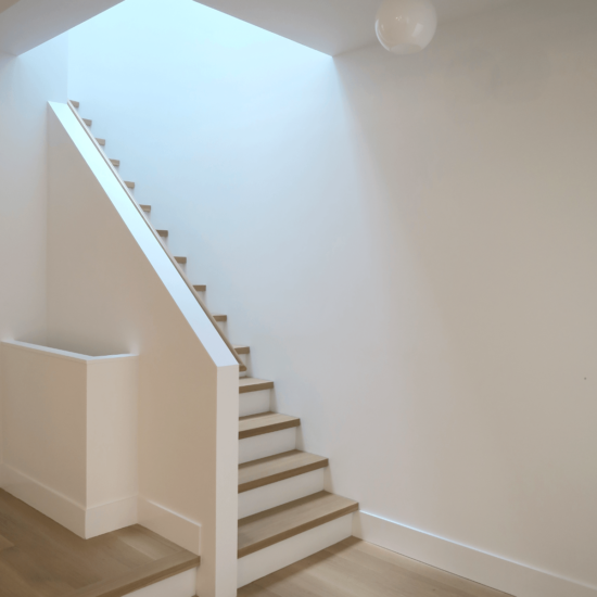 a room with a stair case and light fixture