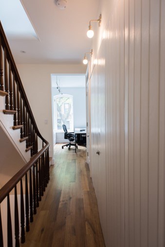 a long hallway with wooden floors and white walls