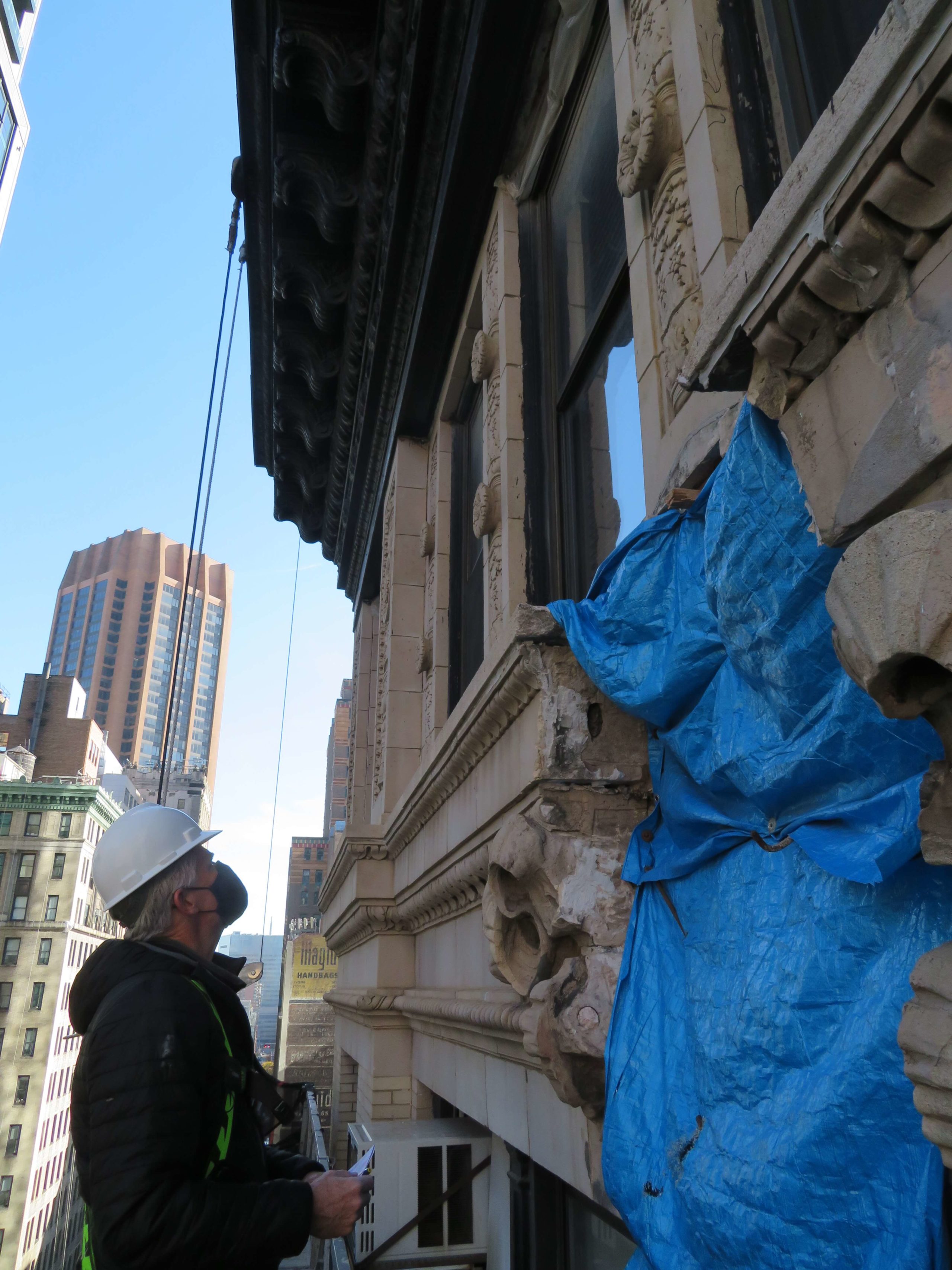 a man in a hard hat is standing next to a building