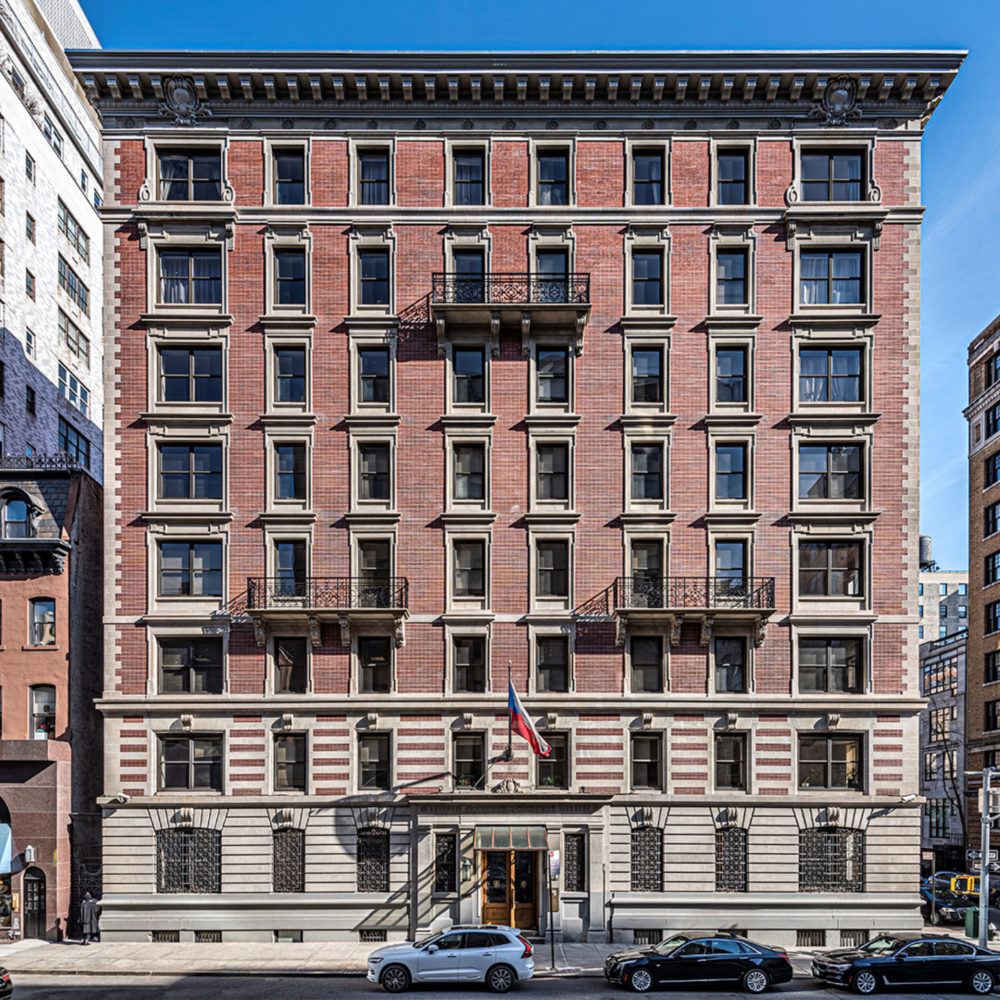 an old brick building with cars parked in front