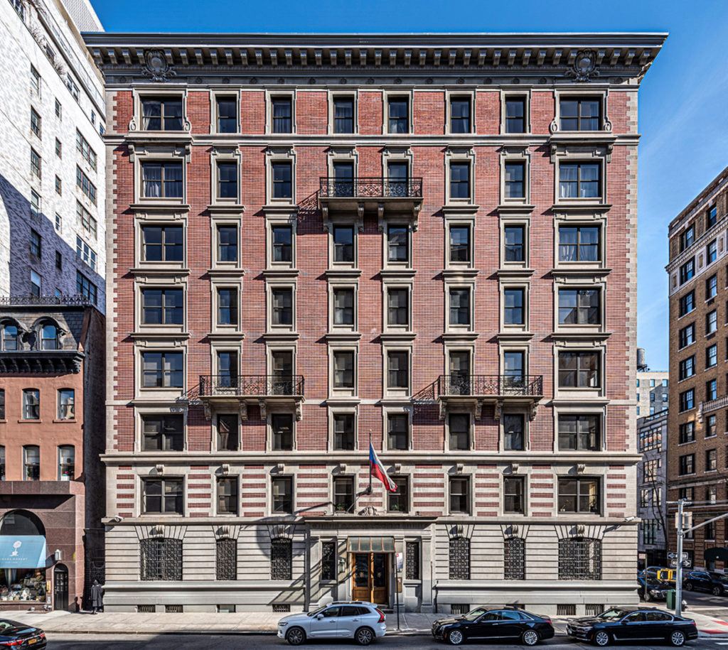 an old brick building with cars parked in front