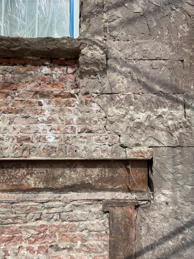 an old brick building with a window on the side