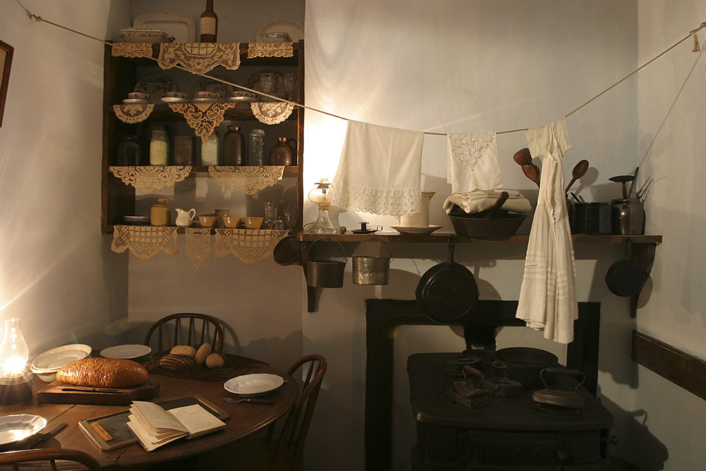 an old fashioned kitchen with a table and stove