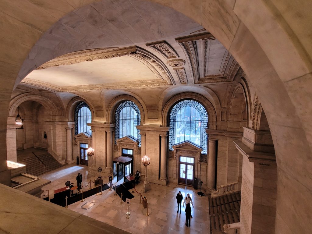 a large building with arched windows and people walking around