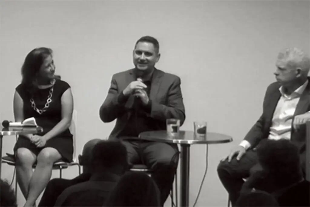 three people sitting in chairs talking to each other
