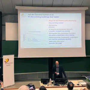 Dispatch From Innsbruck: International Passive House Conference 2 a man giving a presentation to a group of people