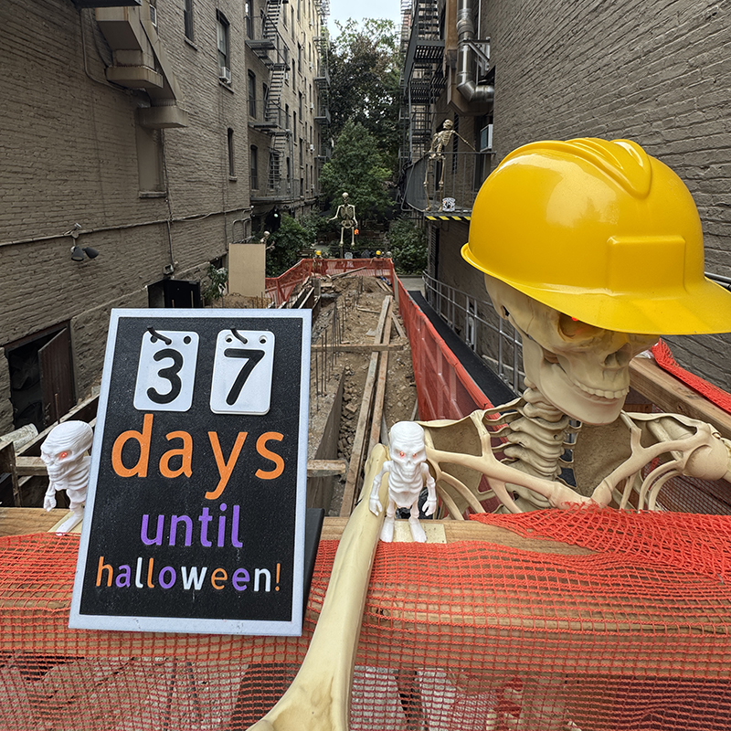 Skeleton in a hard hat on site at the top of the ramp under construction.